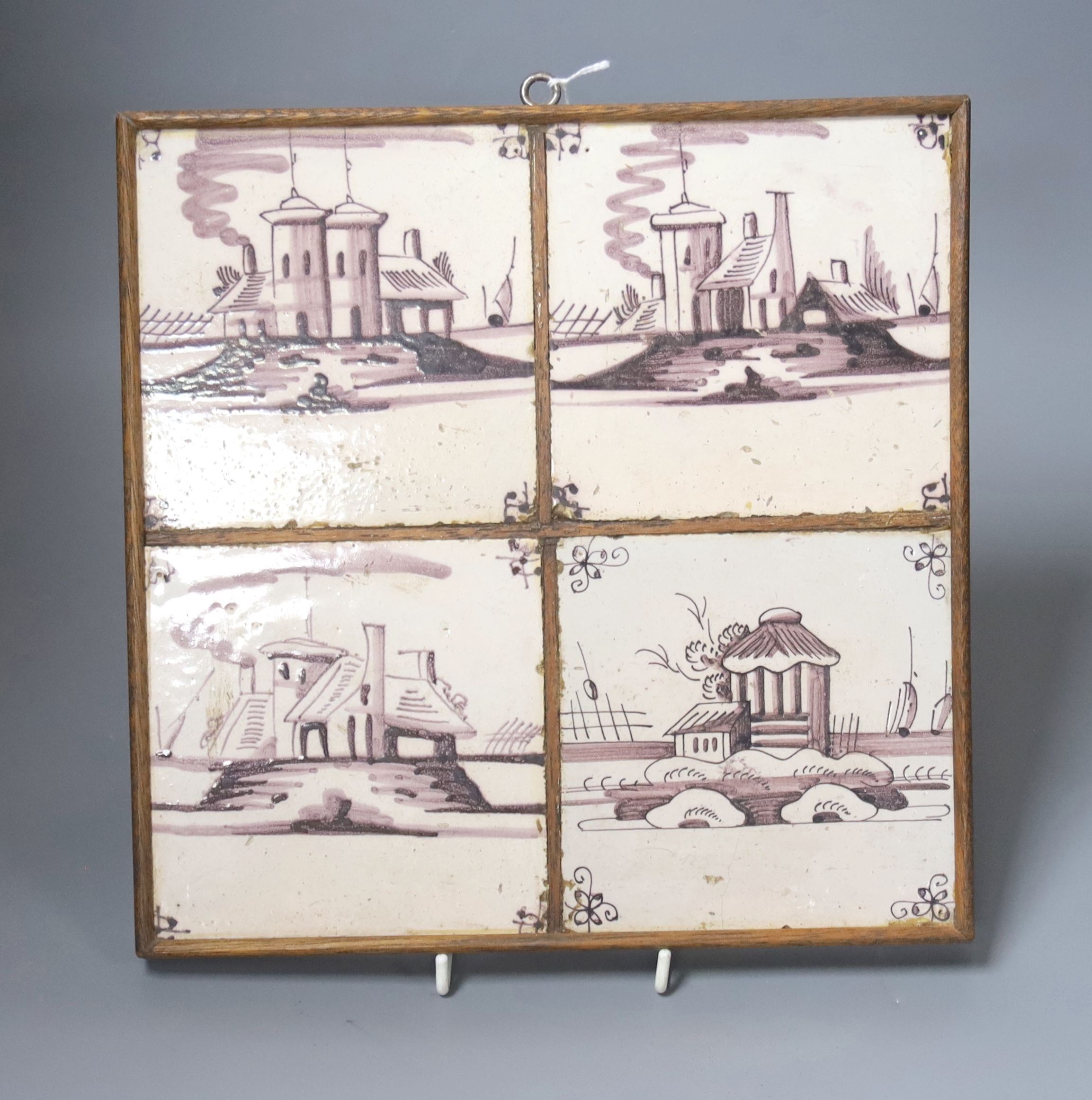 A set of four 18th century Dutch Delft manganese tiles decorated with buildings by a canal (frame 27cm)